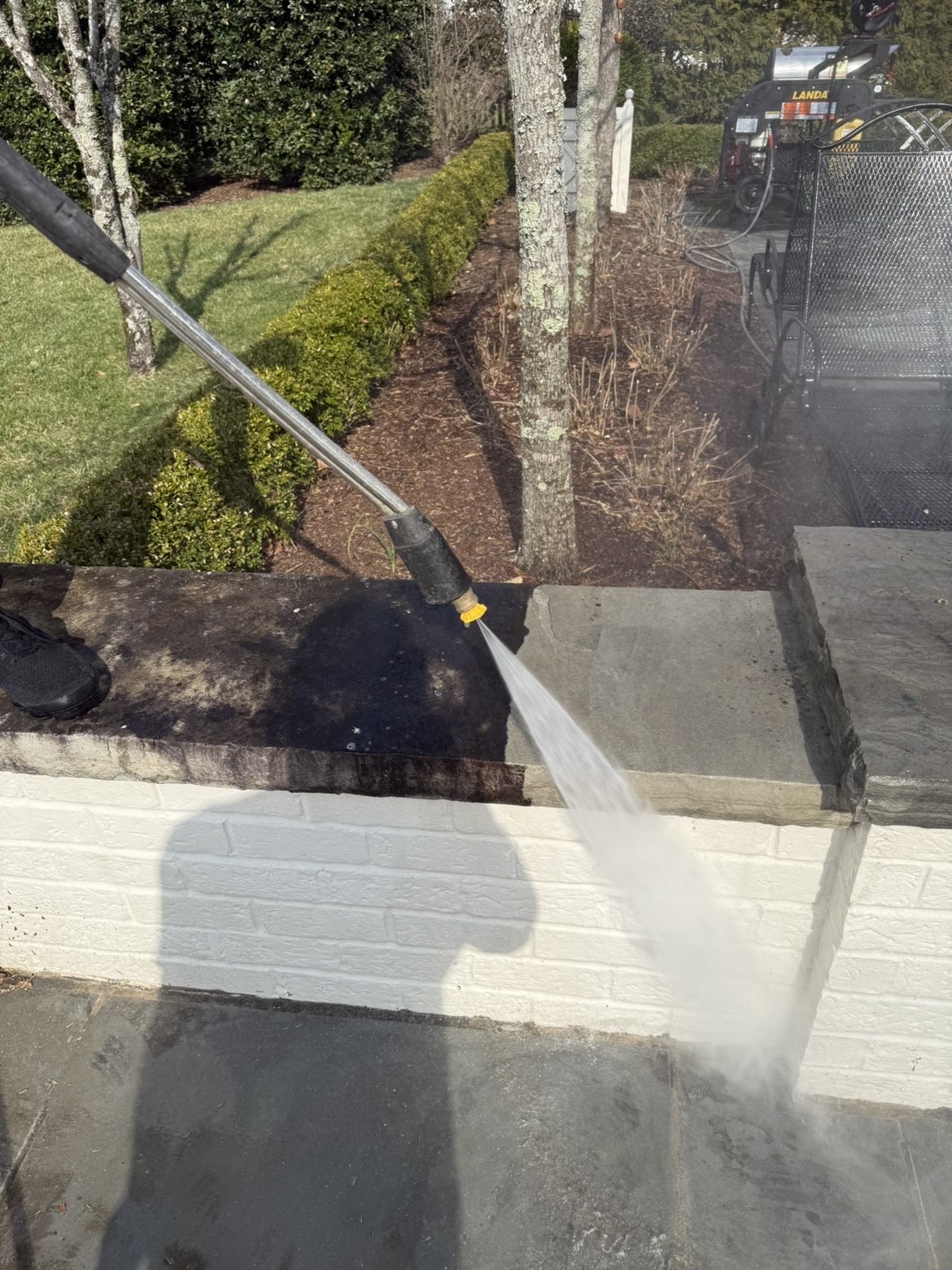 Pressure washing a painted brick wall